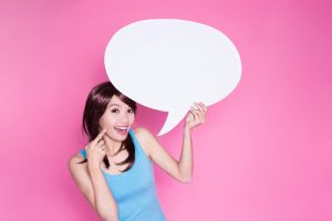 woman take speech bubble and show something on the pink background