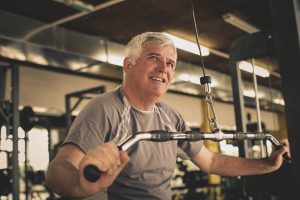 Active senior man working exercise in the gym. Man workout in gym.