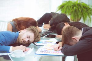 Bored business people sleeping in a meeting colleague.