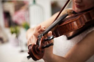 Girl playing the violin. Hand of a girl and a fiddle.