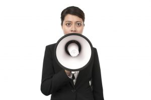 Business women speaking into megaphone