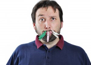 Man with his mouth closed shut by close pins 