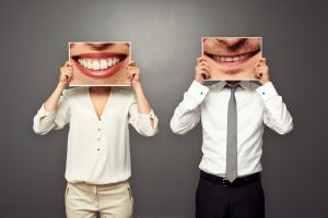 woman and man holding pictures with big smile. concept photo over dark background