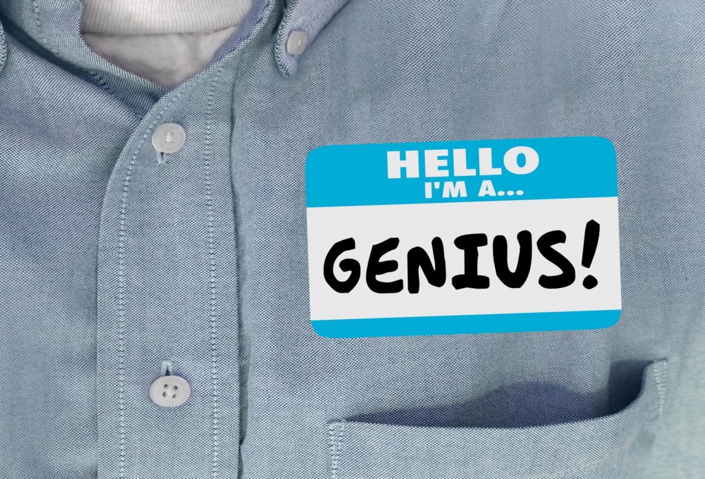 Person wearing a name tag that establishes presence by saying "HELLO I'M A GENIUS" 