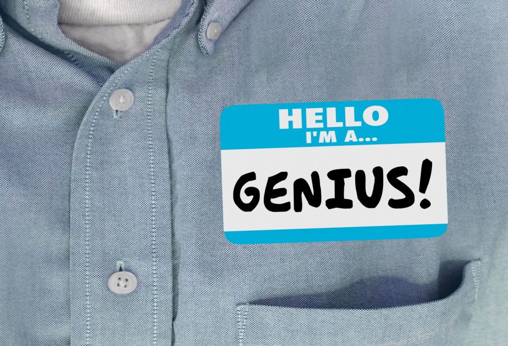 Person wearing a name tag that establishes presence by saying "HELLO I'M A GENIUS"