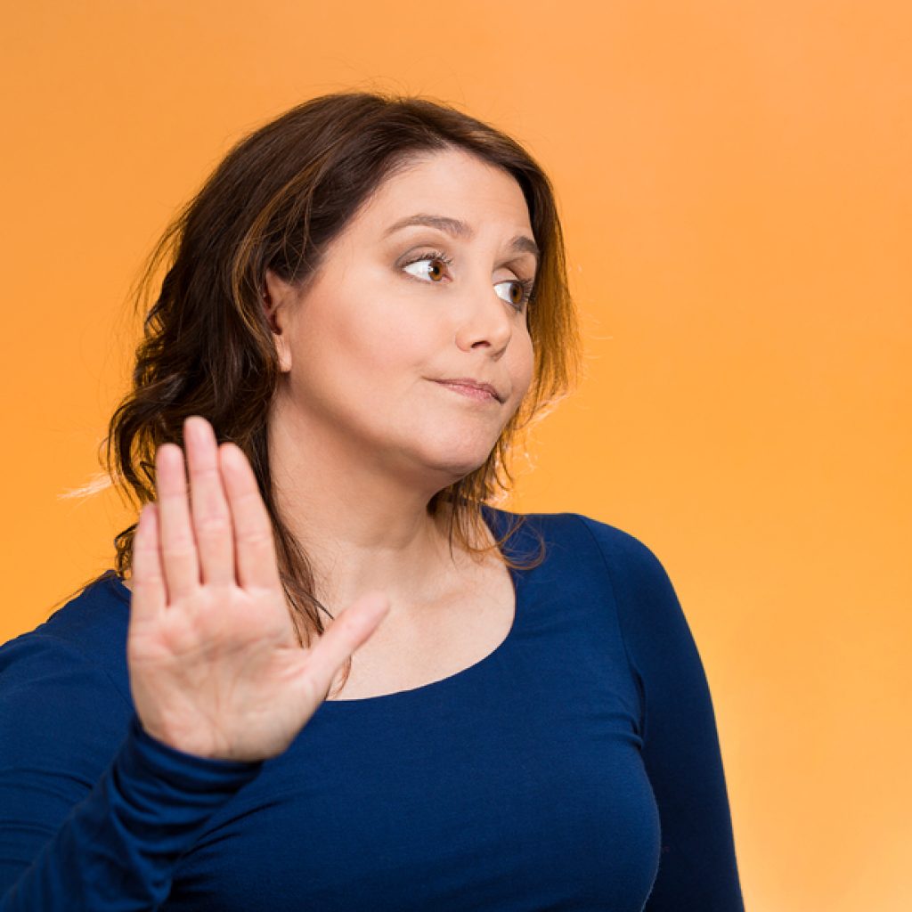Businesswomen with an upset expression signaling talk to the hand